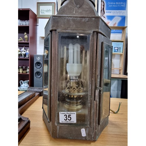 35 - A large wall hanging metal lantern with an electric bulb fitting along with a oak wall hanging barom... 