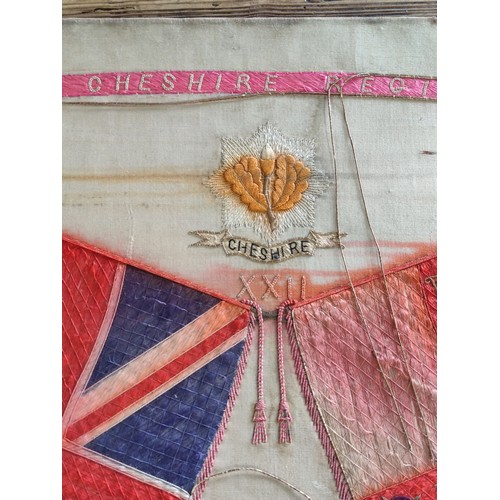 85 - A framed silk of the Cheshire regiment depicting 2 regimental flags and the Cheshire emblem to the t... 