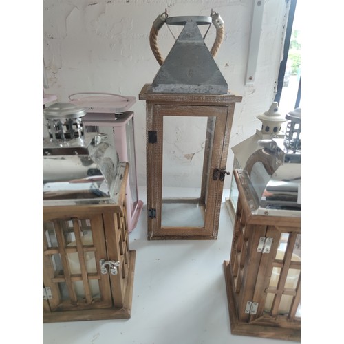 120 - 6 x Pillar candle lanterns some wooden some steel 2 are battery operated with a small qty of vases. ... 