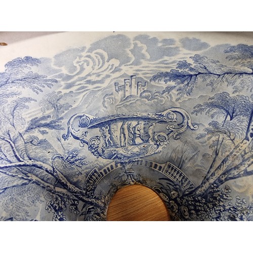 72 - An antique ceramic blue and white toilet bowl, removed from Powis Castle with a intricate scene with... 