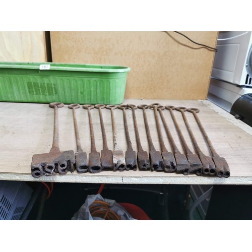 187 - Large quantity of vintage branding irons in a plastic trug, mostly with different letters or numbers... 