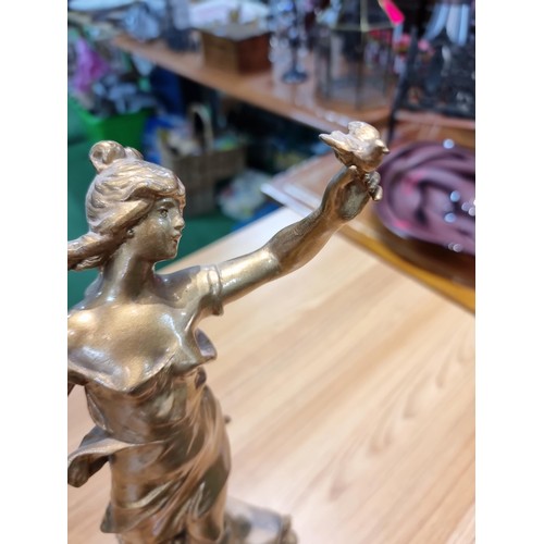 370 - An impressive gilt Spelter figure of a lady holding a dove and a letter in the other hand, set on a ... 