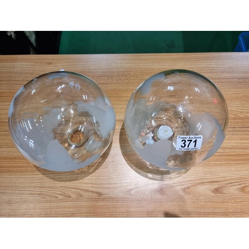 371 - A pair of decorative glass world globes on wooden stands, one inset with a battery operated tealight... 