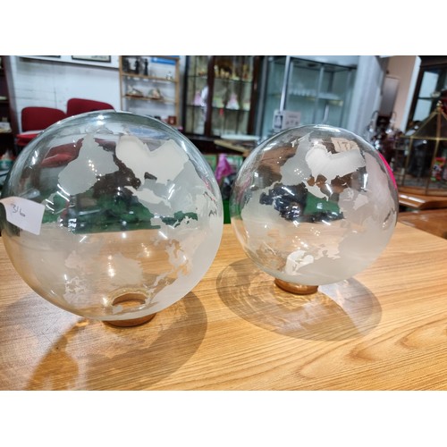 371 - A pair of decorative glass world globes on wooden stands, one inset with a battery operated tealight... 