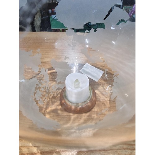 371 - A pair of decorative glass world globes on wooden stands, one inset with a battery operated tealight... 