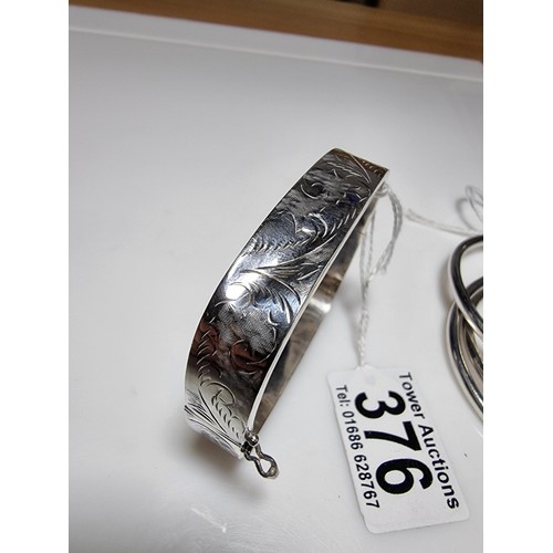 376 - A tested as sterling silver 3 piece bangle, along with an ornate engraved 925 silver hinged bracelet... 