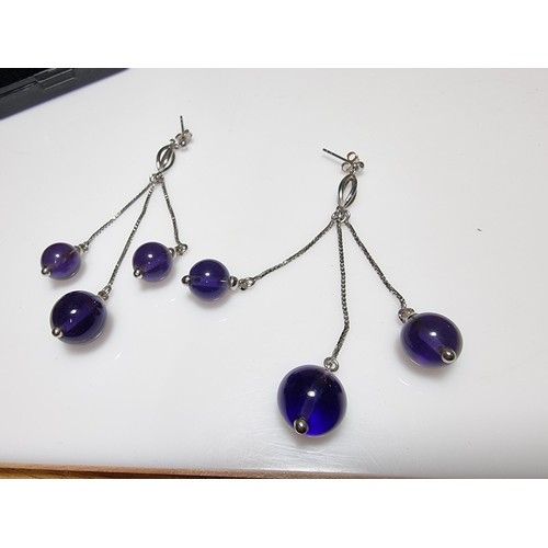 377 - A pair of 925 silver long drop earrings with 3 Amethyst bead ends. Length of the drop is 7cm, in goo... 