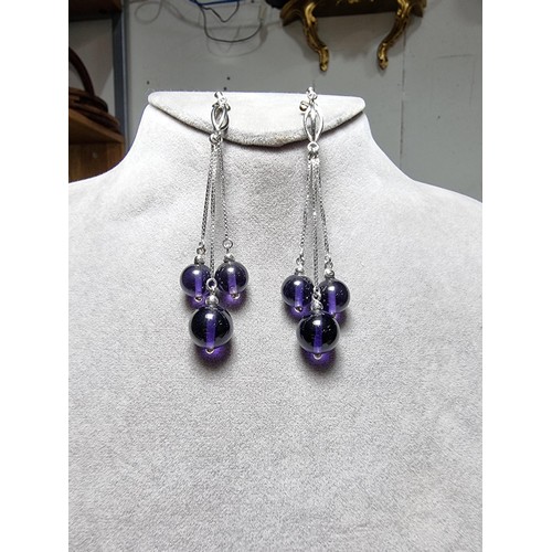 377 - A pair of 925 silver long drop earrings with 3 Amethyst bead ends. Length of the drop is 7cm, in goo... 