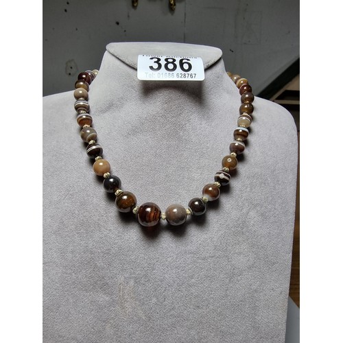 386 - A pretty hand knotted beaded necklace with banded agate beads, presenting good colours, in good clea... 