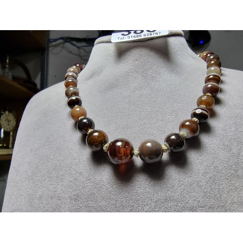 386 - A pretty hand knotted beaded necklace with banded agate beads, presenting good colours, in good clea... 