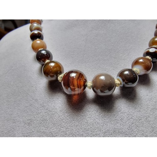 386 - A pretty hand knotted beaded necklace with banded agate beads, presenting good colours, in good clea... 