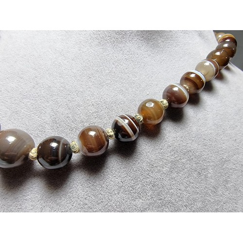386 - A pretty hand knotted beaded necklace with banded agate beads, presenting good colours, in good clea... 