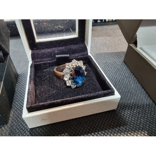 396 - A quantity of boxed dress rings and a silver plated bracelet to include an ornate ring with an aura ... 