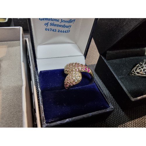 396 - A quantity of boxed dress rings and a silver plated bracelet to include an ornate ring with an aura ... 