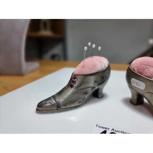 402 - A pair of metal shoe formed pin cushions with a quantity of pins in good clean condition. Height of ... 