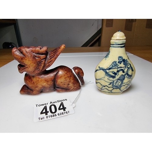 404 - A Chinese ceramic blue and white snuff bottle with a scene of a man on horse to the front and a land... 