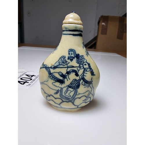 404 - A Chinese ceramic blue and white snuff bottle with a scene of a man on horse to the front and a land... 
