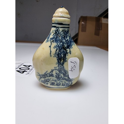 404 - A Chinese ceramic blue and white snuff bottle with a scene of a man on horse to the front and a land... 