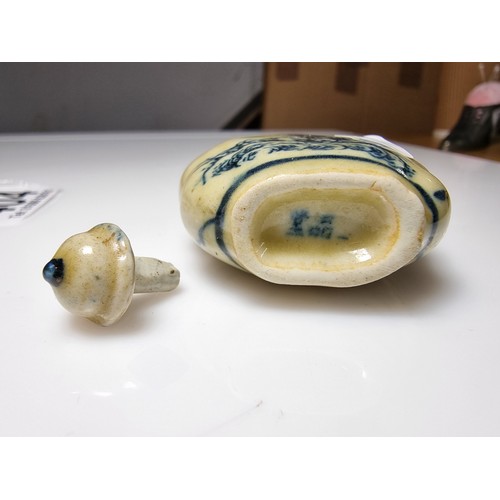 404 - A Chinese ceramic blue and white snuff bottle with a scene of a man on horse to the front and a land... 