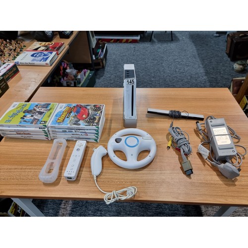 145 - A Nintendo Wii games console complete with 10 games inc Mario Kart controllers, the Mario Kart wheel... 