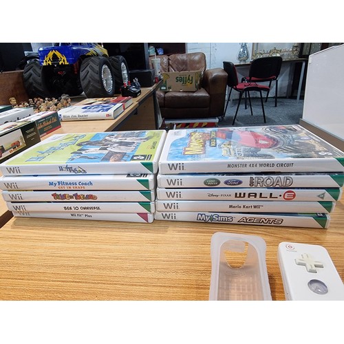 145 - A Nintendo Wii games console complete with 10 games inc Mario Kart controllers, the Mario Kart wheel... 