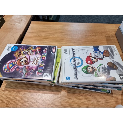 145 - A Nintendo Wii games console complete with 10 games inc Mario Kart controllers, the Mario Kart wheel... 