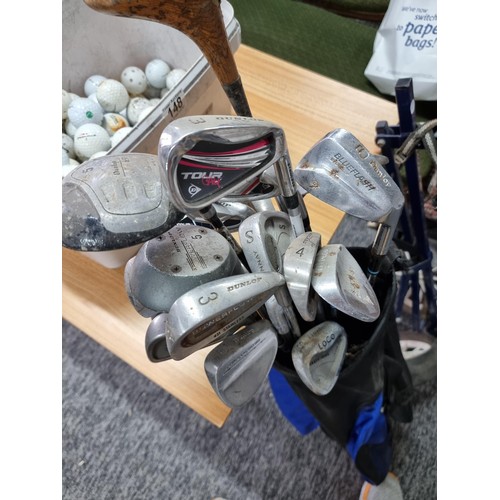 148 - A large quantity of golf clubs of various sizes and makers along with a large bucket full of golf ba... 