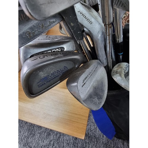 148 - A large quantity of golf clubs of various sizes and makers along with a large bucket full of golf ba... 