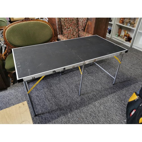 101 - A large folding aluminium table with black surface in overall good condition a few minor scratches t... 