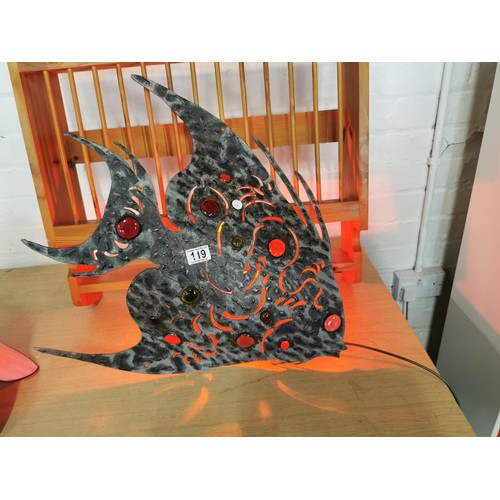 119 - Metal formed large wall hanging fish light with coloured glass inserts lit up with a red bulb stands... 