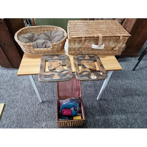 187 - 2 wicker picnic baskets with contents along with a wicker dog bed and 2 large solid wood carved ethn... 