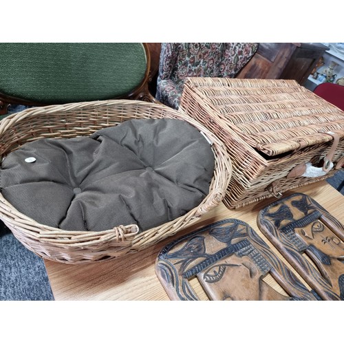 187 - 2 wicker picnic baskets with contents along with a wicker dog bed and 2 large solid wood carved ethn... 