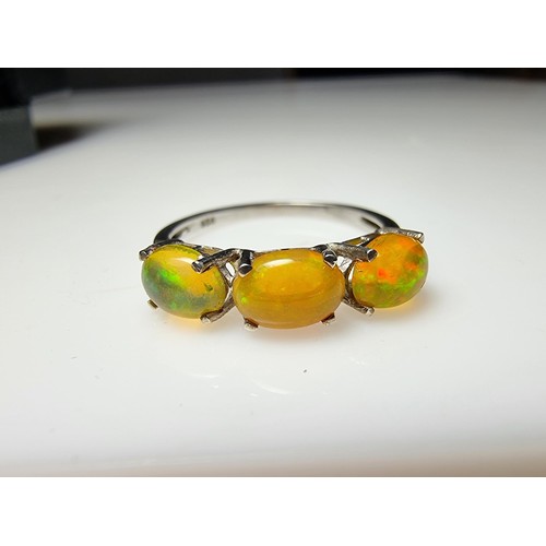 255 - A pretty 925 silver 3 stone dress ring inset with genuine Ethiopian opal stones presenting and orang... 