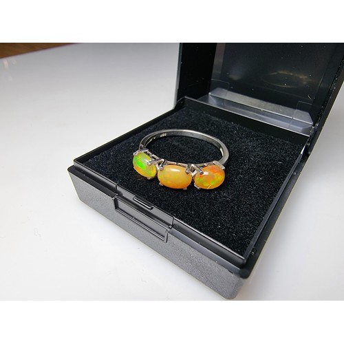 255 - A pretty 925 silver 3 stone dress ring inset with genuine Ethiopian opal stones presenting and orang... 