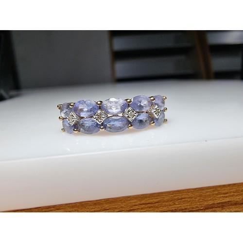 256 - A hallmarked 9ct yellow gold dress ring inset with 10 iolite gemstones and 4 small diamonds in excel... 