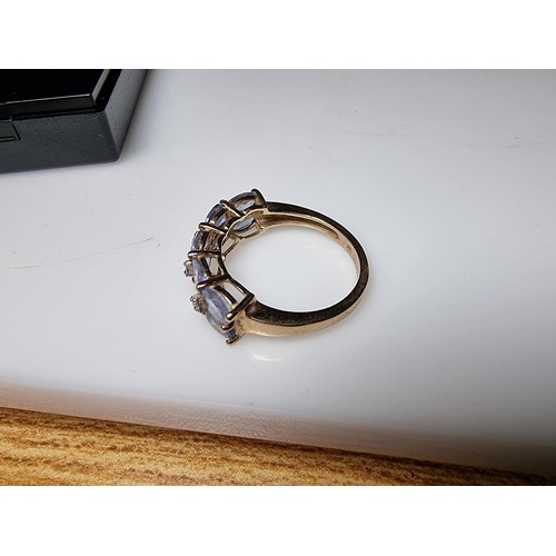 256 - A hallmarked 9ct yellow gold dress ring inset with 10 iolite gemstones and 4 small diamonds in excel... 