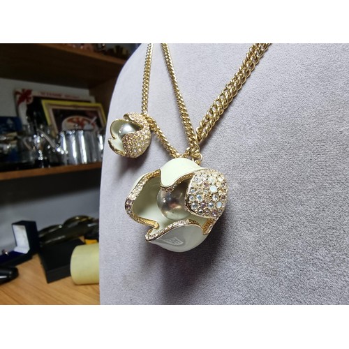 264 - A genuine Swarovski unusual enamelled flower pendant and charm on a double gold tone neck chain, pen... 