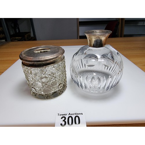 300 - A crystal glass pot with a hallmarked silver top along with a crystal glass scent bottle with a ster... 