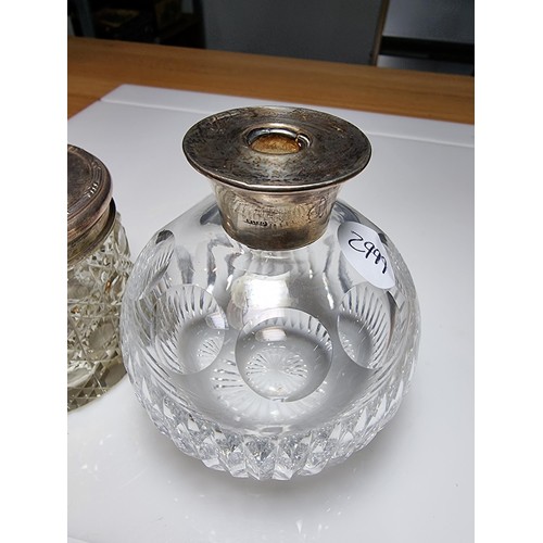 300 - A crystal glass pot with a hallmarked silver top along with a crystal glass scent bottle with a ster... 