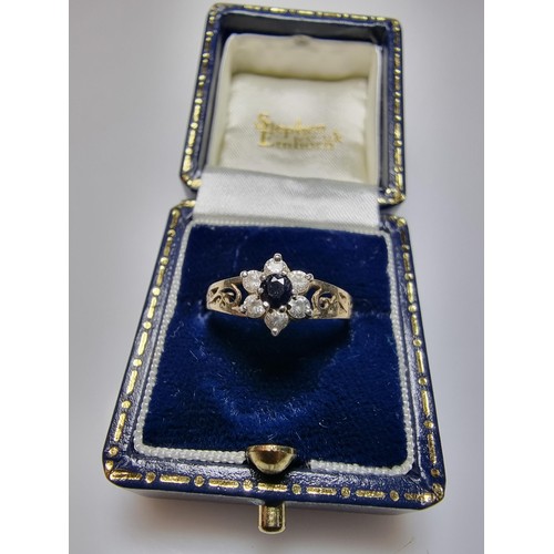 284 - A pretty gold on 925 silver flower ring inset with a blue sapphire stone a clear CZ stones, in clean... 