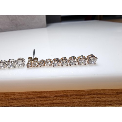 290 - A pair of impressive as new 925 silver drop stud earrings inset with graduated crystal CZ stones whi... 