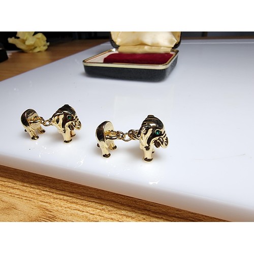 298 - A pair of unused vintage 18k gold plated elephant formed cufflinks with green gemstone eyes, never h... 