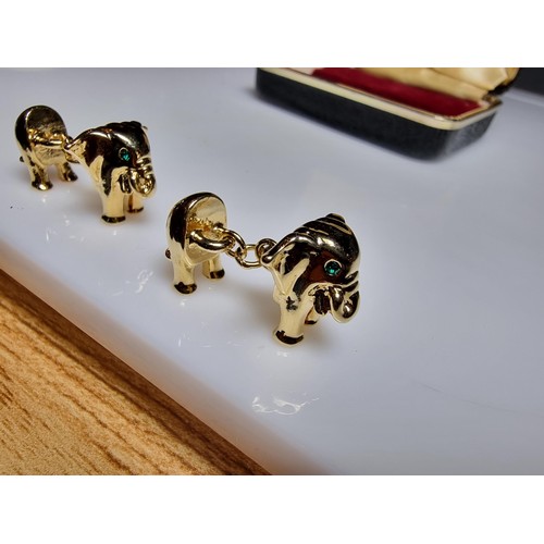 298 - A pair of unused vintage 18k gold plated elephant formed cufflinks with green gemstone eyes, never h... 