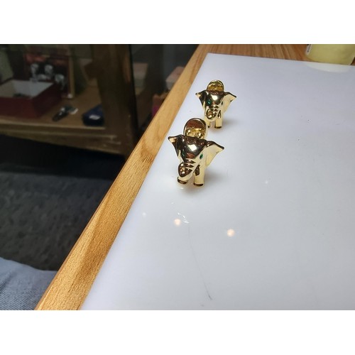 298 - A pair of unused vintage 18k gold plated elephant formed cufflinks with green gemstone eyes, never h... 