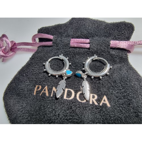 293A - A pair of new and unused silver Pandora earrings with a feather and heart drop charms.