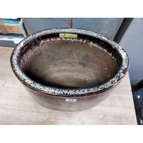 54 - A large terracotta oval brown drip glaze garden planter. height 38cm length 46cm depth 32cm