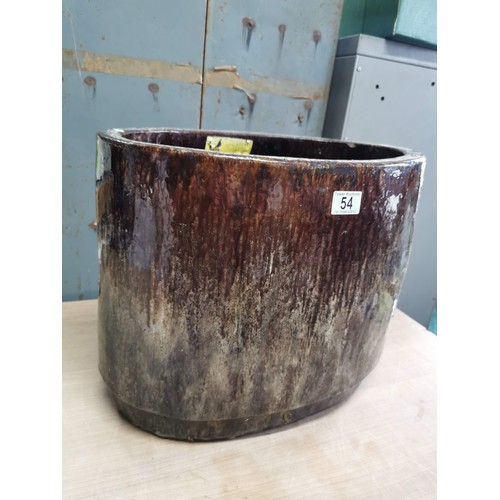 54 - A large terracotta oval brown drip glaze garden planter. height 38cm length 46cm depth 32cm