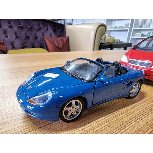 140 - 3 large die-cast model cars all by Maisto to include Porsche Boxster and a Smart car 1/18 scale.