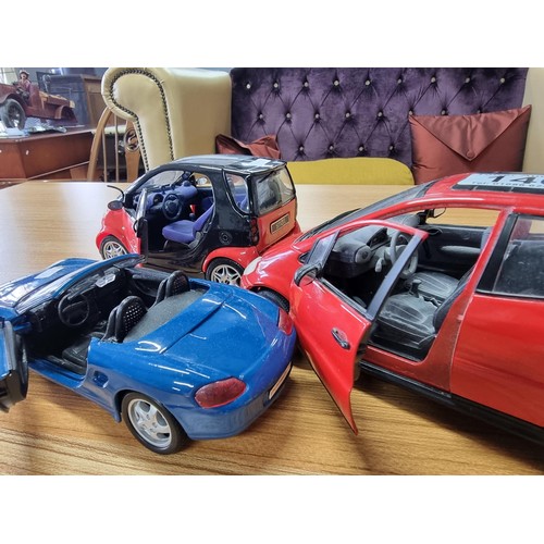 140 - 3 large die-cast model cars all by Maisto to include Porsche Boxster and a Smart car 1/18 scale.