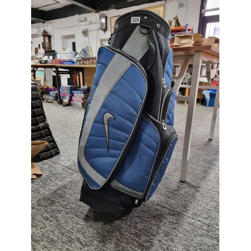 229 - A good quality modern Nike golf bag with large padded pockets and a large padded strap, in clean con... 